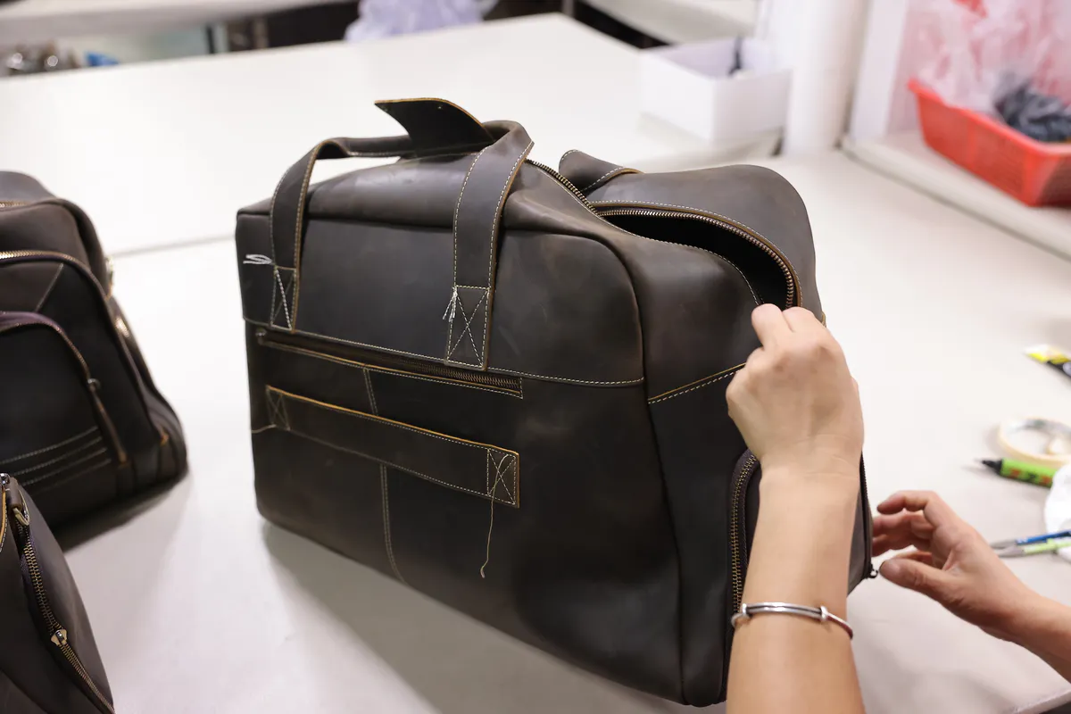 Marrant team member reviewing a custom leather bag sample