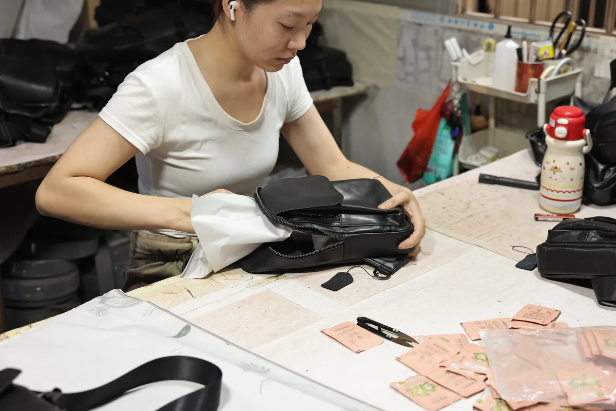 Marrant worker carrying out finished leather goods inspection