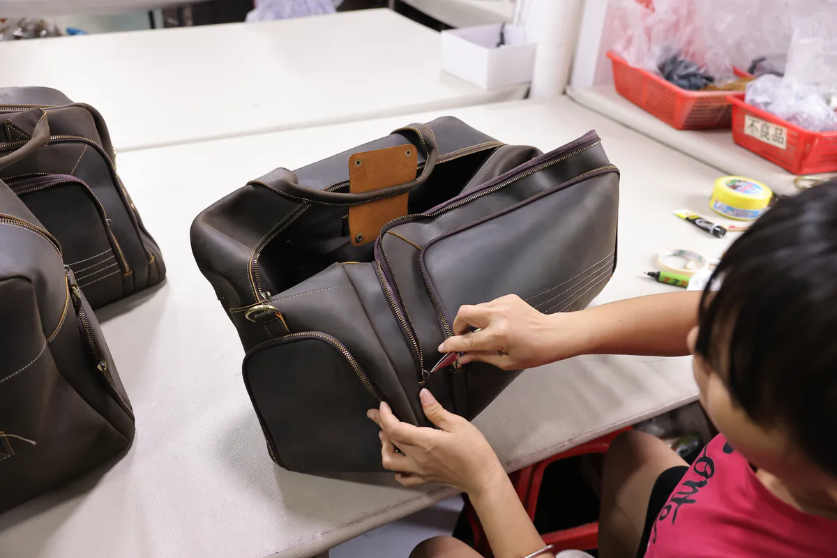 Marrant team member reviewing a leather bag sample