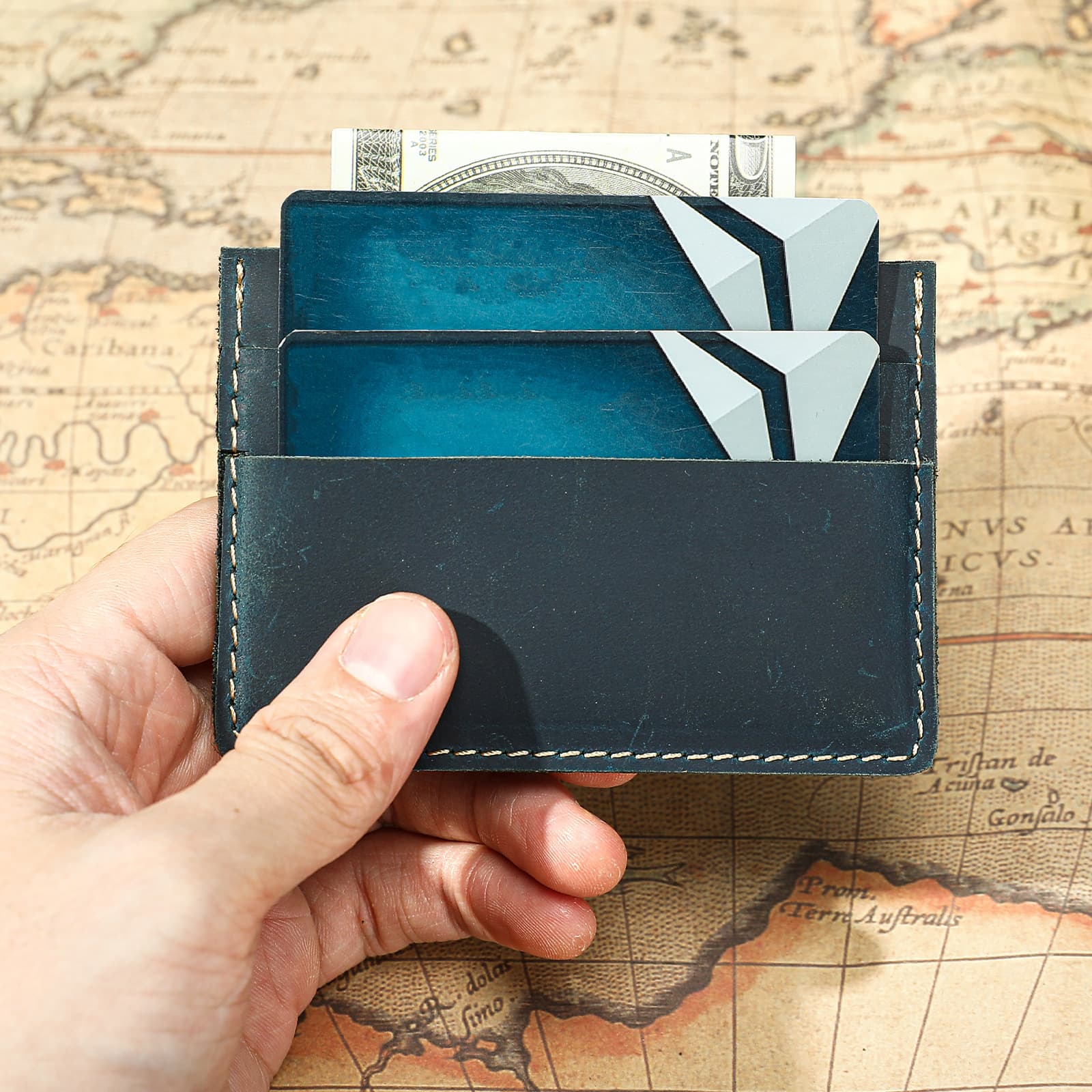 Blue style 1343 leather card holder carrying cards and folded cash for scale